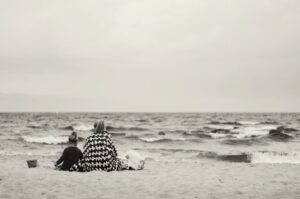 mamma con figlia sedute sulla spiaggia