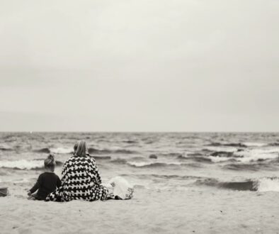 mamma con figlia sedute sulla spiaggia